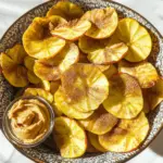 - 2 large apples (Honeycrisp or Fuji) - 1 teaspoon ground cinnamon - 1 tablespoon coconut sugar (or granulated sugar) - Pinch of salt - Mandoline slicer or sharp knife - Baking sheets - Parchment paper You can use many apples for this recipe. Honeycrisp and Fuji apples work great. They are sweet and hold their shape well when baked. When selecting apples, look for firm ones without bruises. A ripe apple should feel heavy for its size. The skin should be smooth and shiny. If you find apples that smell sweet, that’s a good sign! Also, try to pick apples that are in season for the best flavor. First, preheat your oven to 225°F (107°C). This low heat will help dry the apples slowly. Next, line two baking sheets with parchment paper. This helps prevent sticking and makes cleanup easy. Now, wash and dry the apples thoroughly. I like to use Honeycrisp or Fuji apples for their sweet flavor and crisp texture. Using a mandoline slicer or a sharp knife, slice the apples into thin, even rounds. Aim for about 1/8 inch thick. Keep the skin on for added nutrition and color. If you want, you can remove the seeds and core, but it is not necessary. In a small bowl, mix together 1 teaspoon of ground cinnamon, 1 tablespoon of coconut sugar, and a pinch of salt. This blend adds a warm, sweet flavor to your chips. Arrange the apple slices in a single layer on the prepared baking sheets. Make sure not to overlap them. This ensures even baking and crispiness. Next, sprinkle the cinnamon-sugar mixture evenly over the apple slices. Each slice should get enough seasoning for great flavor. Now, place the baking sheets in the preheated oven. Bake for 1 hour, then flip each apple slice over. Continue baking for another 1 to 1.5 hours. Keep a close eye on them towards the end to prevent burning. Once they are dry and crispy, remove the apple chips from the oven. Let them cool completely on the baking sheets. Cooling helps them crisp up even more. Enjoy this crunchy and delicious snack treat! To get the best crunch from your chips, slice the apples evenly. Thin slices, about 1/8 inch thick, help them bake well. Use a mandoline for uniform slices. The right baking temperature is key. I recommend 225°F (107°C). If your chips aren't crisp after the suggested time, add 15 minutes, but check often. One common mistake is overlapping apple slices. This can cause uneven baking. Always lay them flat in a single layer. Another mistake is not letting the chips cool. Cooling helps them reach that perfect crunch. Leave them on the baking sheet until they are completely cool. Baked apple chips are great on their own, but you can get creative. Serve them in a fun bowl and pair with almond or peanut butter. This adds a tasty twist. You can also sprinkle them on yogurt or oatmeal for extra flavor and texture. Enjoying them with friends makes snack time more fun! {{image_2}} You can easily add more taste to your baked apple chips. Try mixing in nutmeg or pumpkin spice. These spices blend well with cinnamon and give a warm flavor. Another fun option is to drizzle your chips with honey or maple syrup. This adds a sweet touch and makes them even more enjoyable. If you want to cut down on sugar, use agave syrup or stevia. These sweeteners work well in this recipe and keep your chips tasty. They also let you enjoy a sugar-free snack without losing flavor. It's a great way to satisfy your sweet tooth! Don’t limit yourself to apples! You can also make chips with pears or sweet potatoes. These fruits bring unique flavors and textures. You can even try using other seasonal fruits, like peaches or mangoes. Each fruit will give your chips a new spin and make snack time more fun. To keep your baked apple chips fresh, use an airtight container. Glass jars or plastic containers work well. Keep them in a cool, dry spot. Proper storage helps them last longer. Aim to enjoy them within a week for the best flavor and crunch. If your apple chips lose their crunch, don’t worry! You can restore their crispiness easily. Put them back in a 225°F (107°C) oven for about 15 minutes. This should help them regain their crunch. If they still seem stale, it may be time to toss them. Fresh snacks are always best! Serve your baked apple chips right after they cool. They taste amazing when fresh! If you plan to store them, keep them in a sealed container. Understand that pre-made chips taste best within a week. Enjoy them while they’re at their peak! For the full recipe, check out the Crispy Cinnamon Baked Apple Chips section. Baked apple chips can last for about 1 to 2 weeks. Store them in an airtight container to keep them fresh. If they lose crunch, you can re-bake them at a low temperature for 10 to 15 minutes. This method brings back their crispiness. Keep them in a cool, dry place away from moisture. Yes, you can make baked apple chips without sugar. Try using spices like cinnamon or nutmeg for flavor. You can also use alternatives like stevia or agave syrup. Adjust the amount based on your taste. The Full Recipe offers a simple method to create tasty chips even without sugar. Baked apple chips are a healthy snack choice. They are low in calories and high in fiber. Apples provide vitamins and minerals, like vitamin C. They can help with digestion and support heart health. Just be mindful of added sugars if you choose to use them. The best apples for making chips are Honeycrisp and Fuji. They have a nice balance of sweetness and tartness. Other great choices include Granny Smith and Pink Lady. These apples hold their shape well when baked. Their flavor shines through, making your chips even more delicious. Yes, you can use a dehydrator to make apple chips. Slice the apples as you would for the oven method. Set the dehydrator to about 135°F (57°C). Arrange the apple slices in a single layer. Dehydrate for 6 to 8 hours, checking for crispness. This method retains more nutrients than baking. Baked apple chips make a tasty snack. We explored key ingredients, tools, and tips. Choosing the right apples is vital for great flavor. You learned to slice, season, and bake them perfectly. Remember to avoid common mistakes, like overlapping slices. Experiment with flavors and fruits to get creative. Store your chips properly to keep them crisp. Enjoy these chips fresh or try out the variations. With this guide, you can make and enjoy delicious baked apple chips any time!